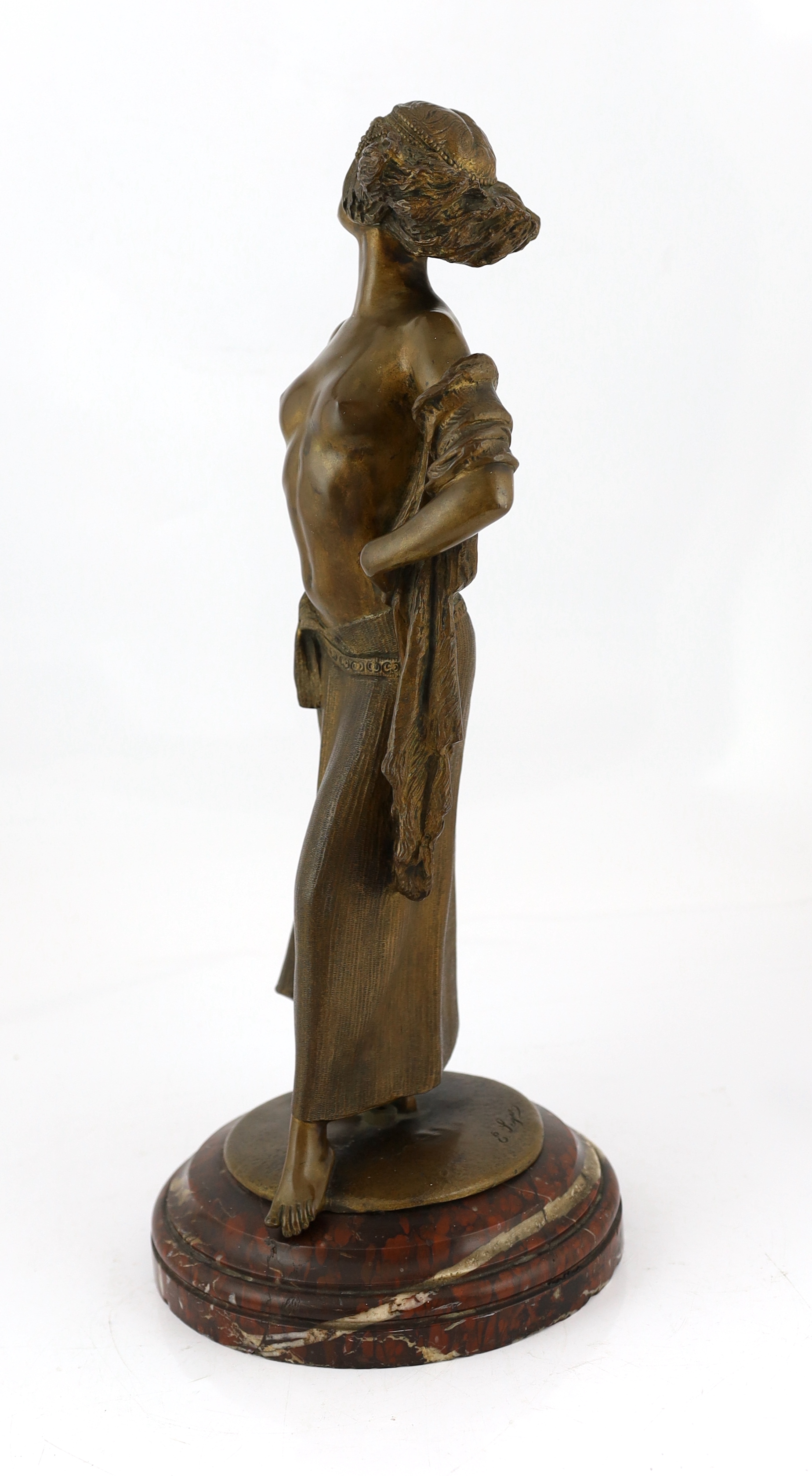 E. Leger - a bronze figure of an Eastern dancer standing with her hands on her hips, signed in the bronze, on rouge marble socle, 53cm high